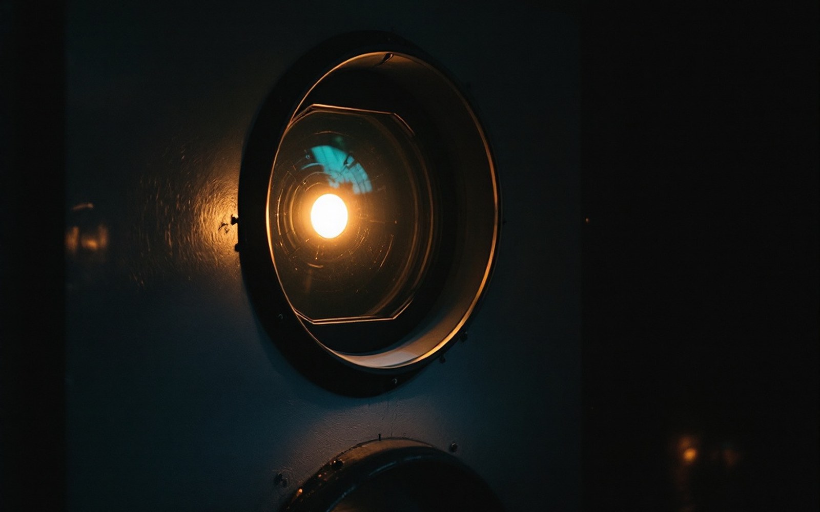 A projection booth port window with the lamp on